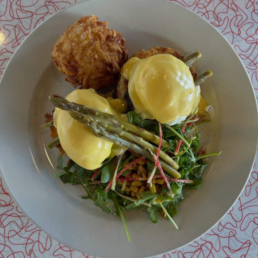 Eggs Benedict with asparagus, greens, and a golden potato side