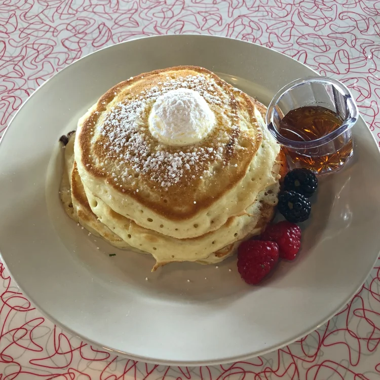 Pancakes topped with berries and syrup