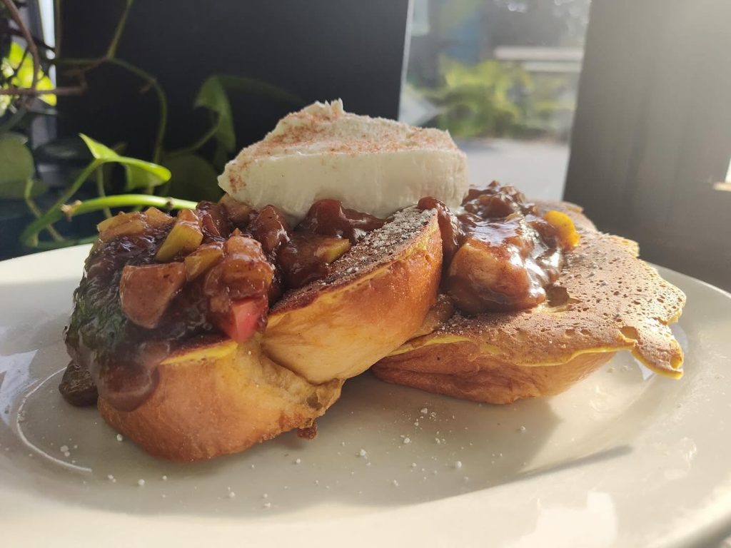 Thick French toast with cooked fruit and a dollop of cream