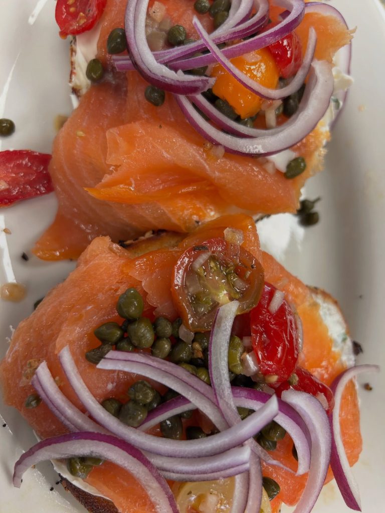 Smoked salmon on bread with capers, tomatoes, and sliced red onion